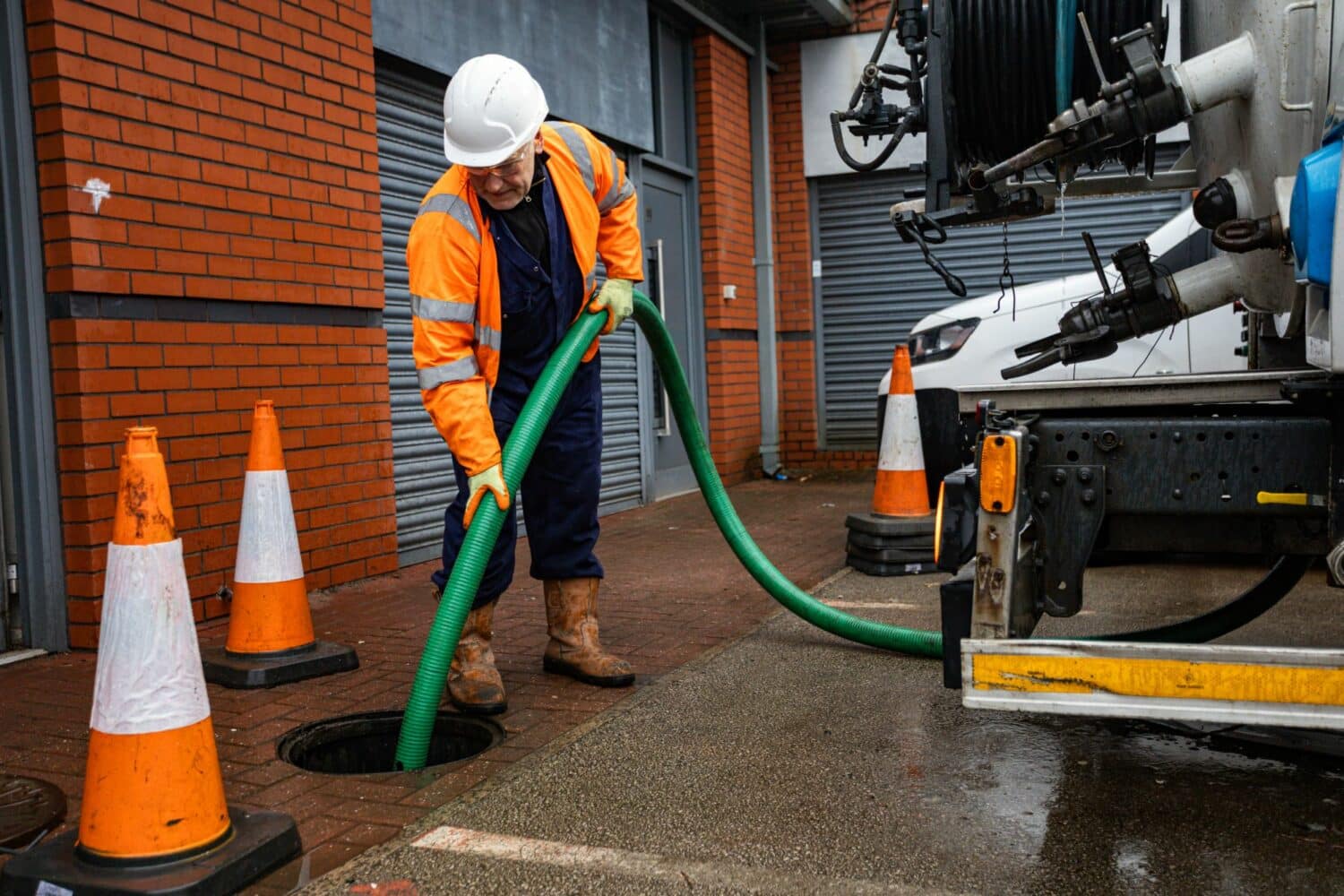 JetVac operator emptying full manhole