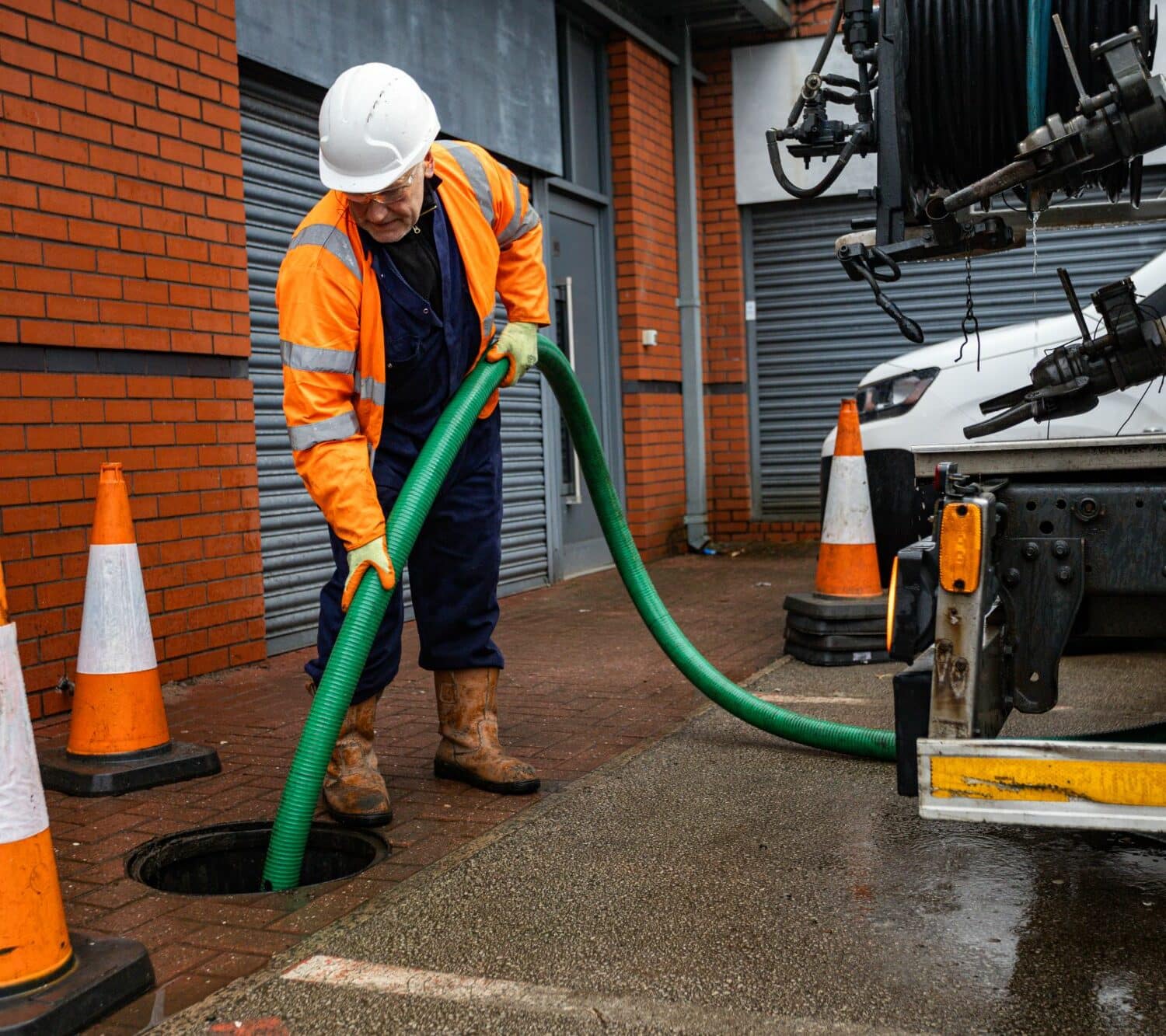 JetVac operator emptying full manhole